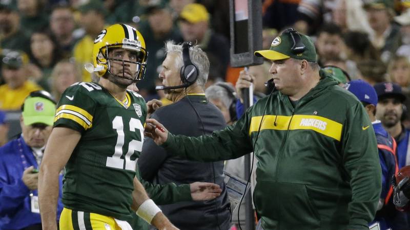 Green Bay Packers head coach Mike McCarthy looks at Aaron Rodgers as he walks off the field...