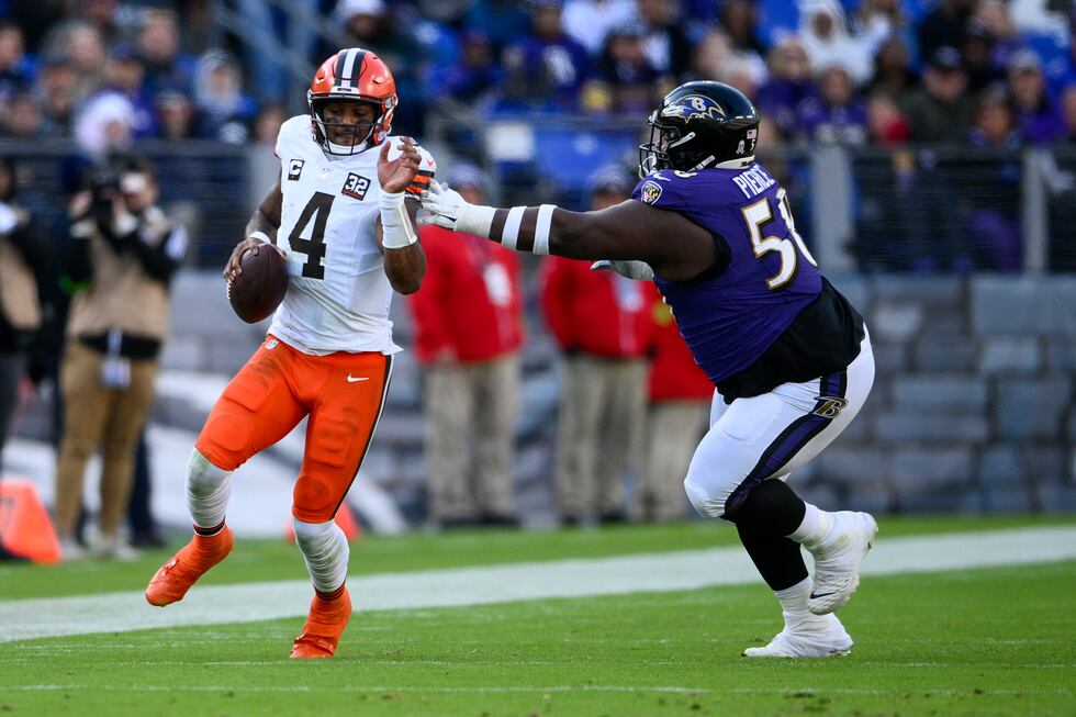 Cleveland Browns quarterback Deshaun Watson runs past Baltimore Ravens defensive tackle...