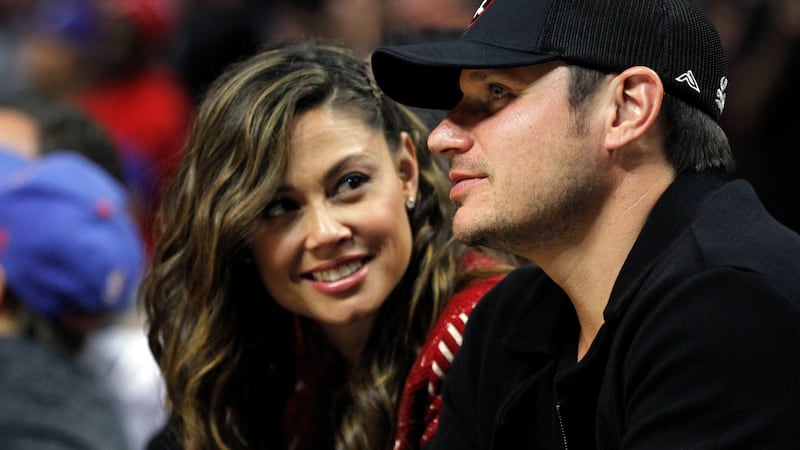Nick Lachey, right, with his wife Vanessa Lachey watch the second half of an NBA basketball...