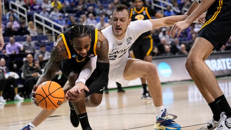 Pittsburgh guard Jamarius Burton (11)a and Xavier forward Jack Nunge (24) reach for a loose...