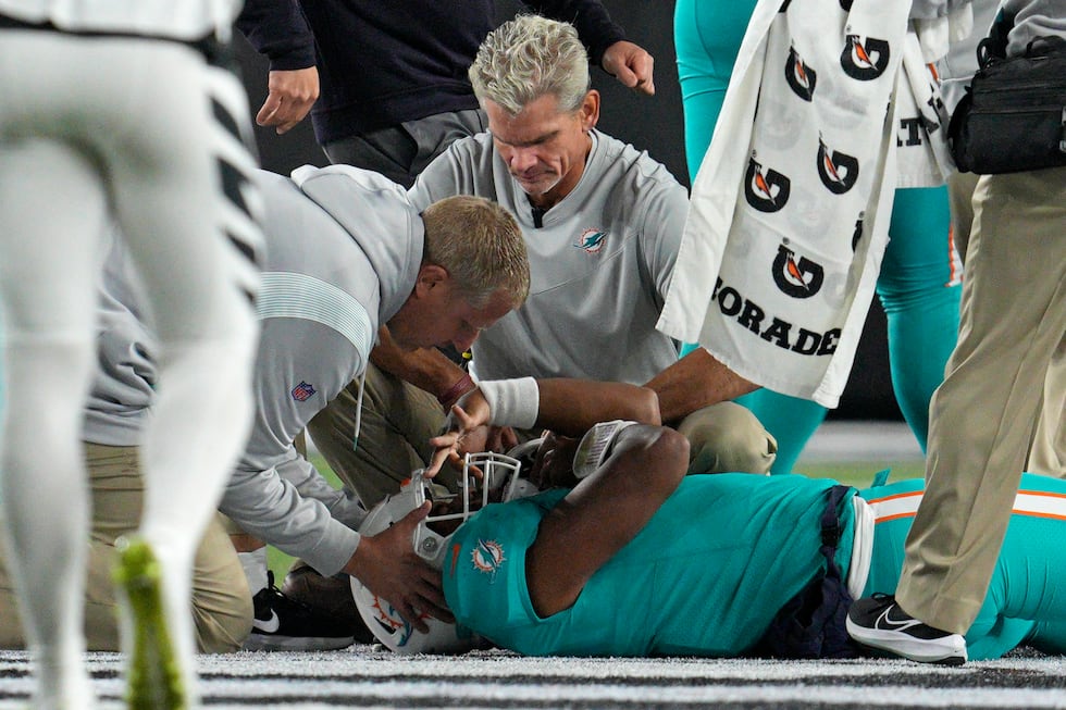 Miami Dolphins quarterback Tua Tagovailoa is examined during the first half of the team's NFL...