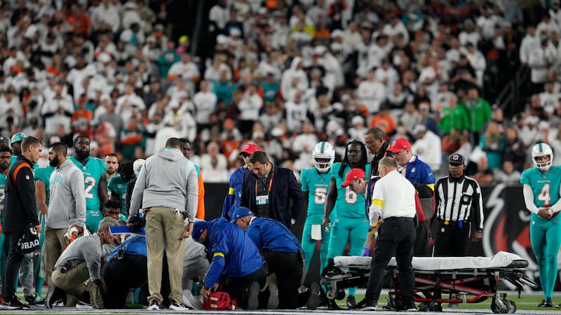 Miami Dolphins quarterback Tua Tagovailoa is examined during the first half of an NFL football...