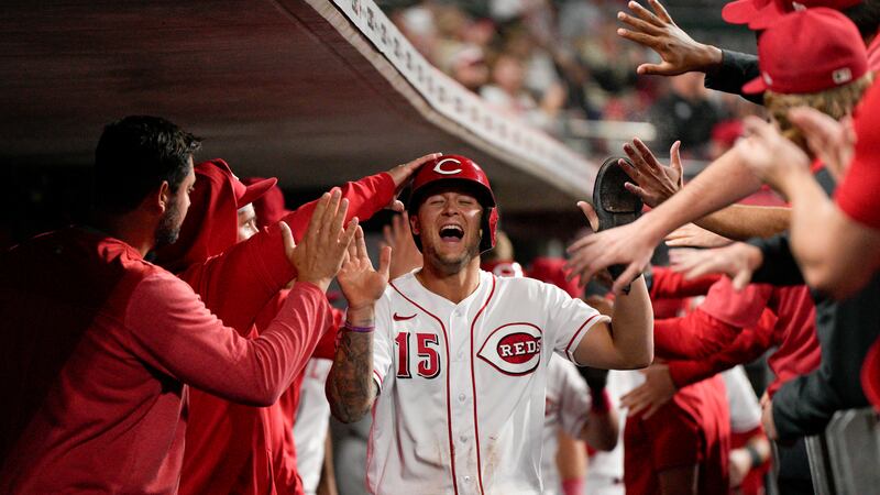 Cincinnati Reds' Nick Senzel (15) celebrates with teammates after scoring on a Joey Votto...