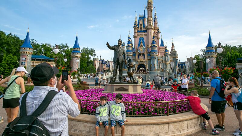 FILE - People visit the Magic Kingdom Park at Walt Disney World Resort in Lake Buena Vista,...